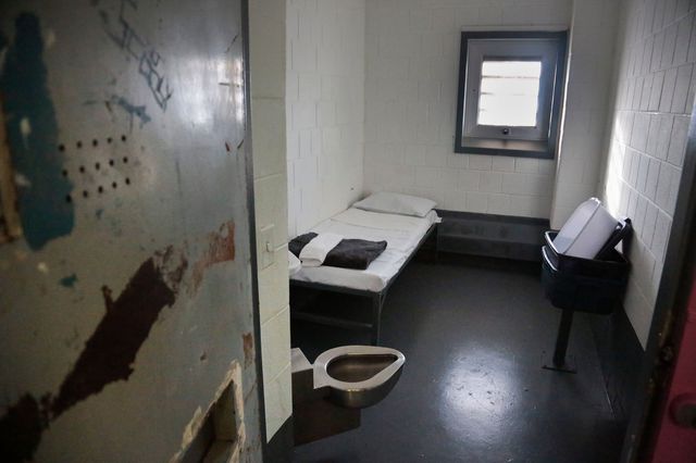 The inside of a solitary confinement cell on Rikers Island in 2017, with a metal cot and a metal toilet.